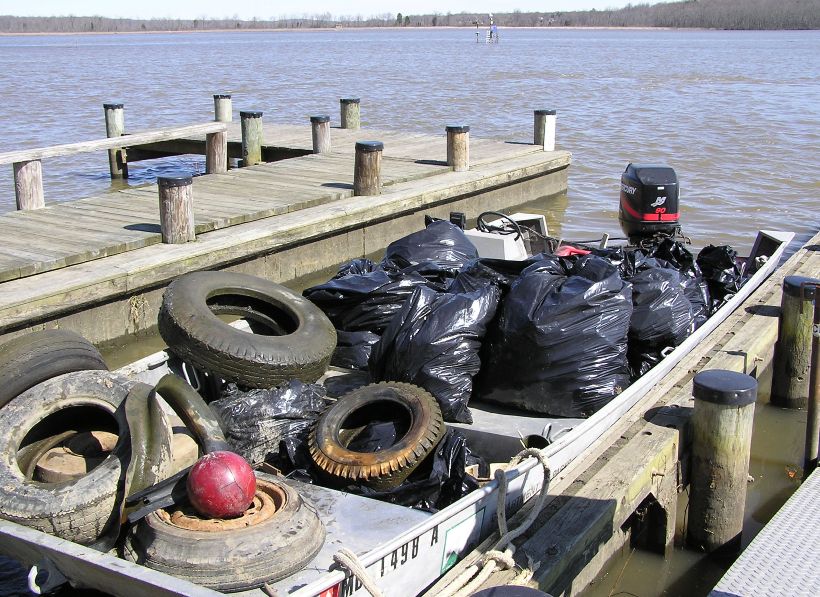 Boat full of trash with red bowling ball at the front