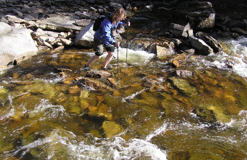 Norma doing stream crossing with hiking poles