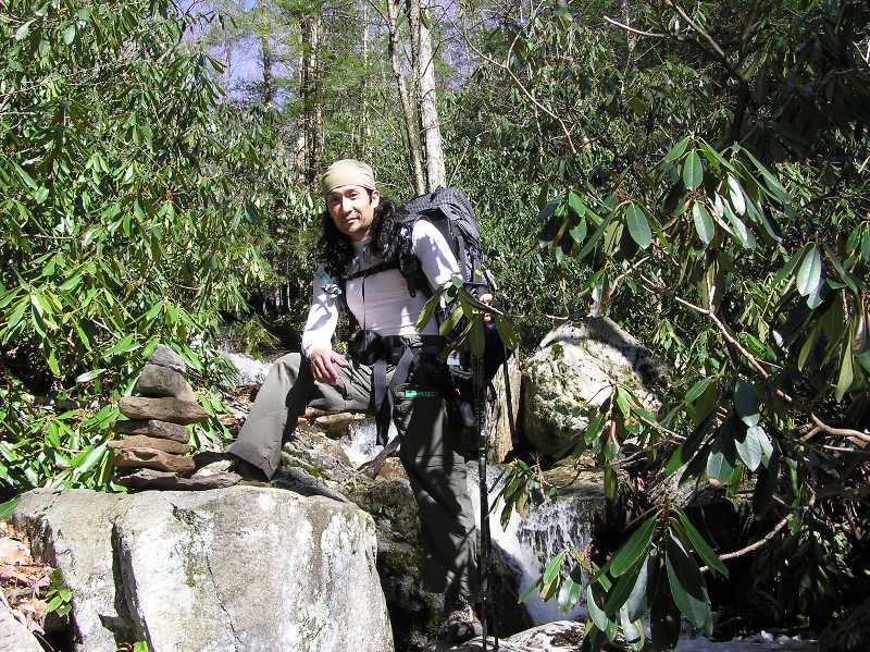 Me with one foot on a rock next to a cairn