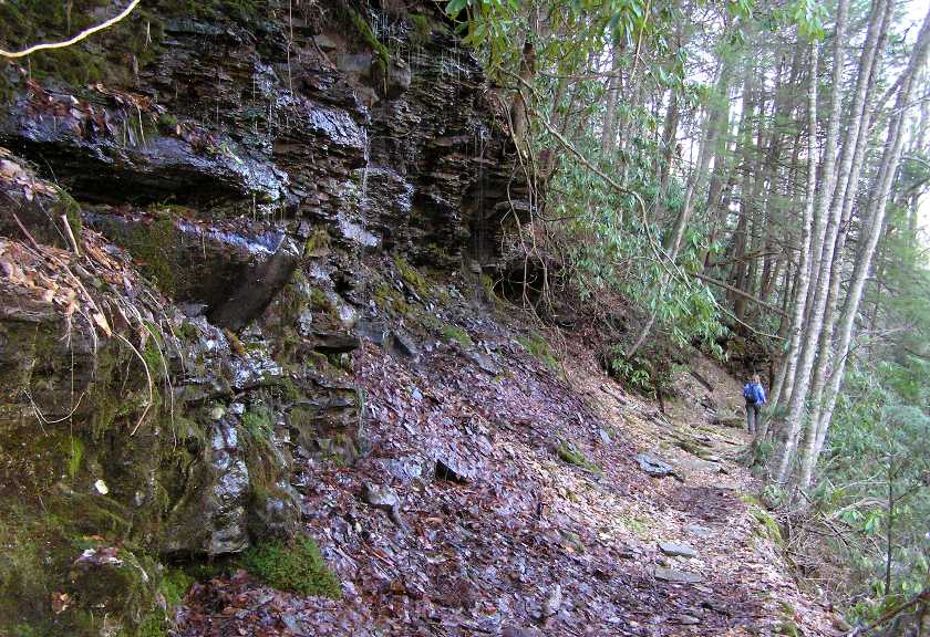 Norma hiking on the trail with steep rocks on the left