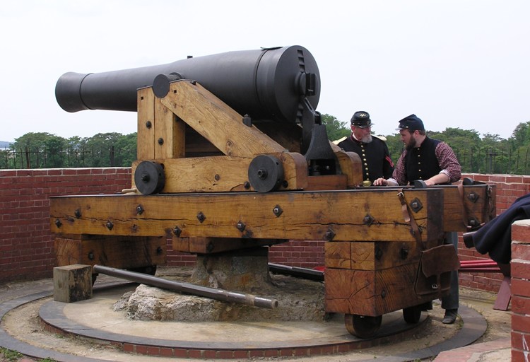 Two men in period costume next to Columbiad Cannon