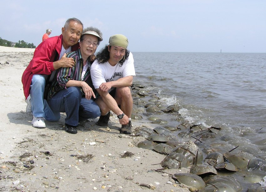 Dad, Mom, and I kneeling beside horseshoe crabs