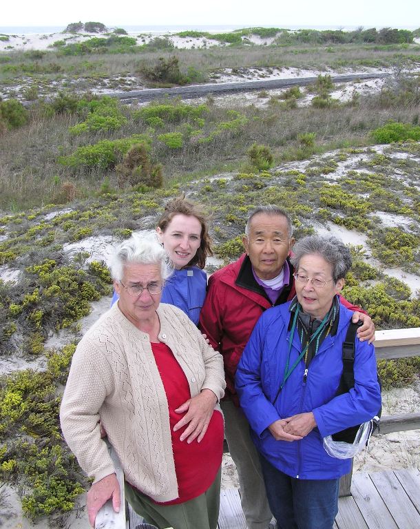 Hazel, Norma, Dad, and Mom standing on platform with old highway behind