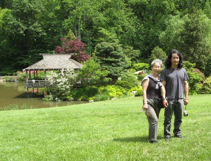 Mom and I standing on a grassy area with an Asiatic structure behind