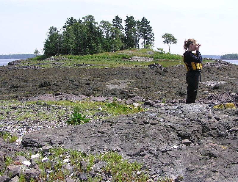 Norma looking through binoculars on island