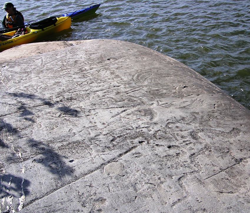 Petroglyph of a serpent shape carving in the lower right