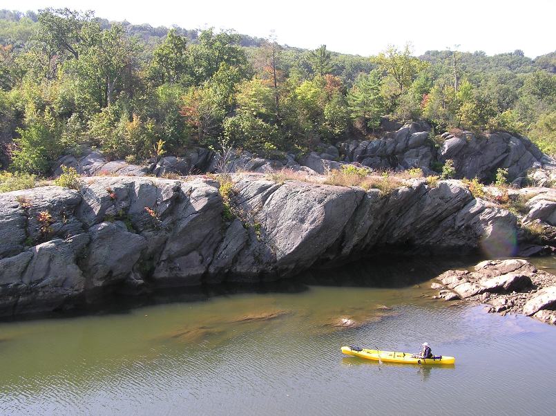 Zoomed out view of Norma in the tandem kayak with big boulders behind