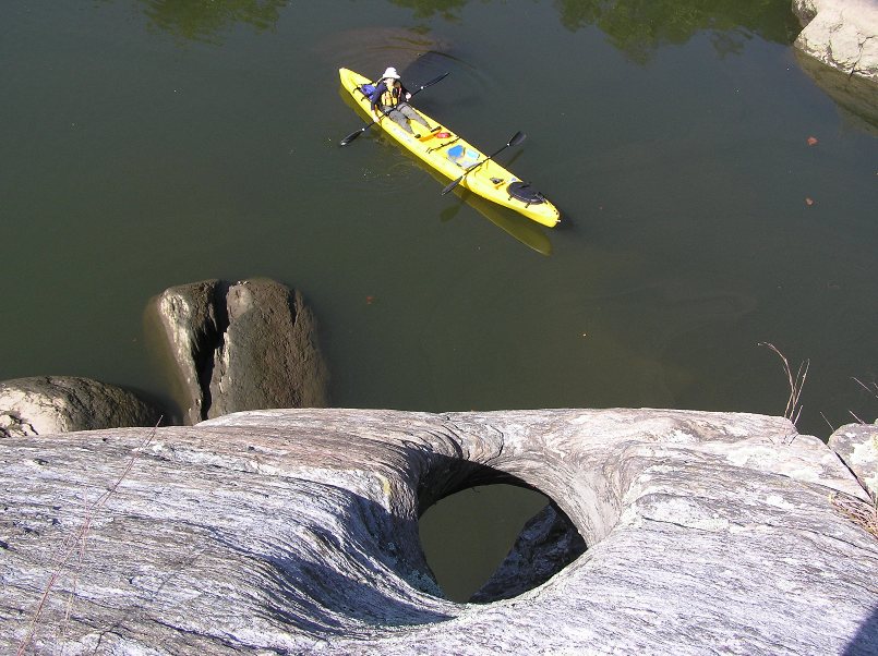 Looking down at a hole in the rock with Norma in the kayak below