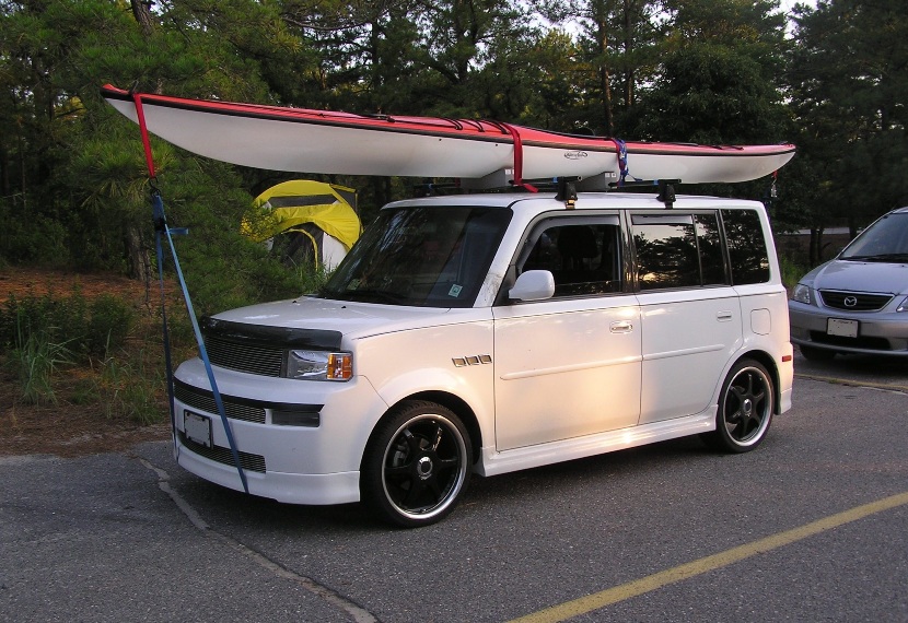 White Toyota Scion with white and red kayak on top