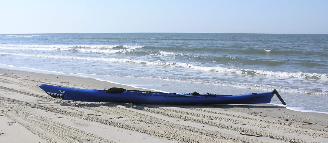 Cobra Expedition kayak with wing paddle on beach