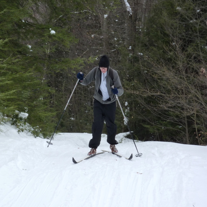 Clark climbing a hill in his skis