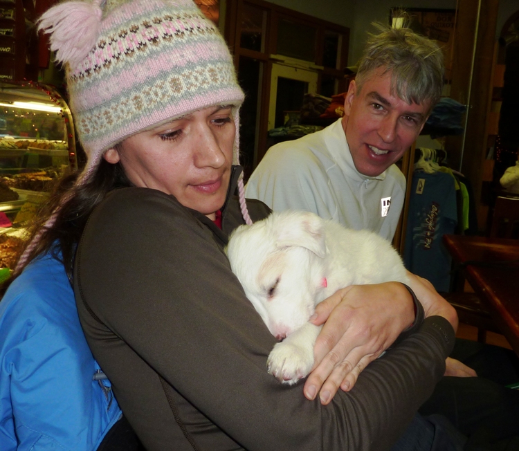 Carmen holding a puppy with Clark behind