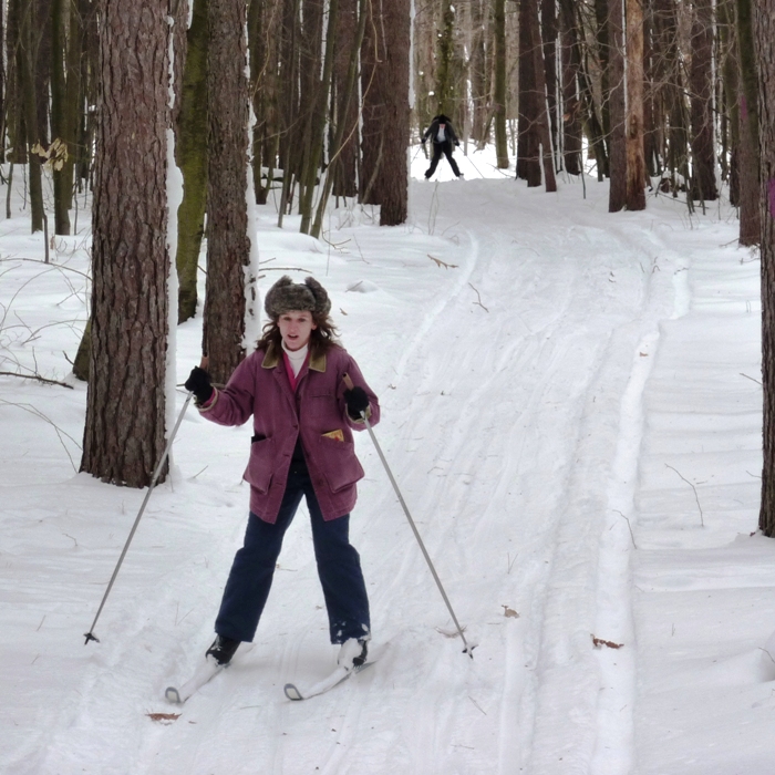 Norma skiing downhill with Clark behind