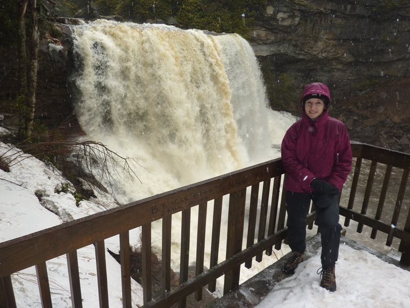 Norma standing on the observation platform with the falls behind her