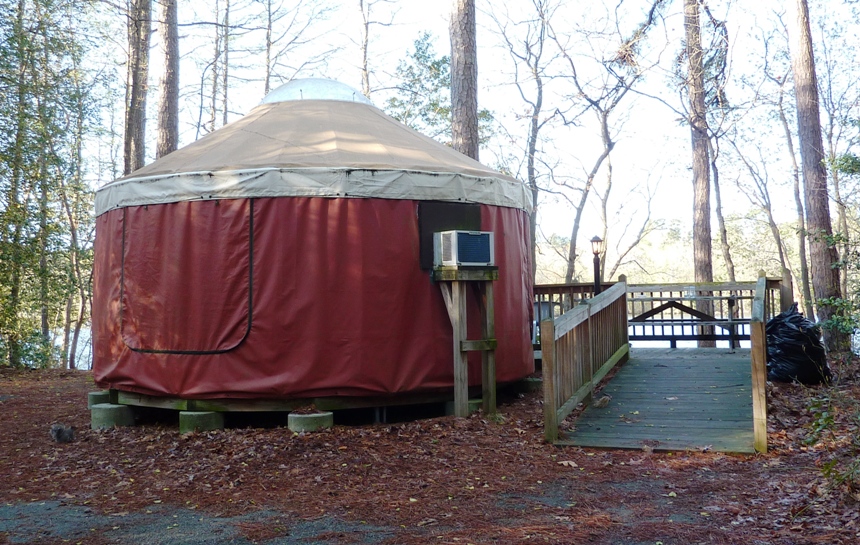 Red yurt with white roof and wooden ramp