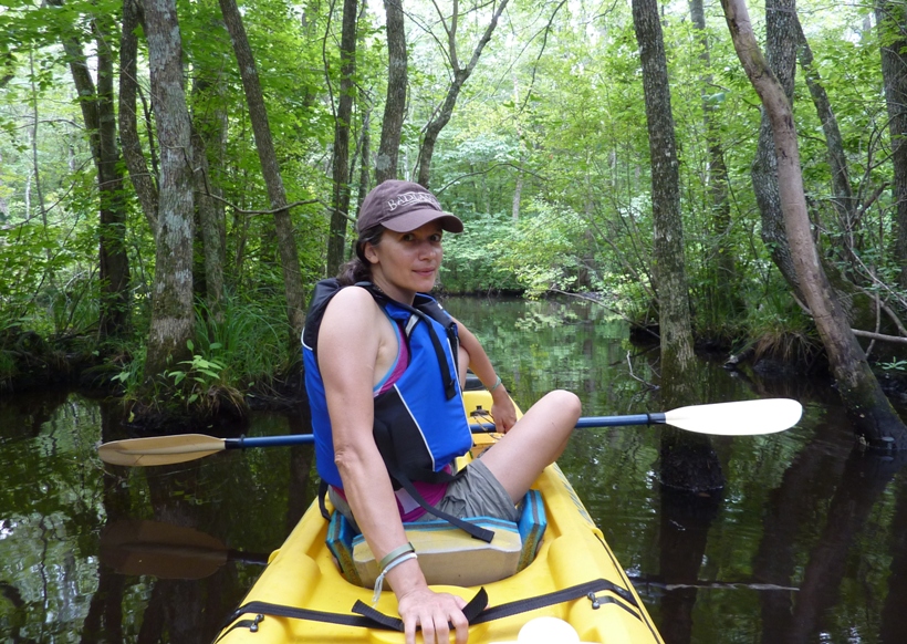 Carmen on a kayak on tree-lined waters