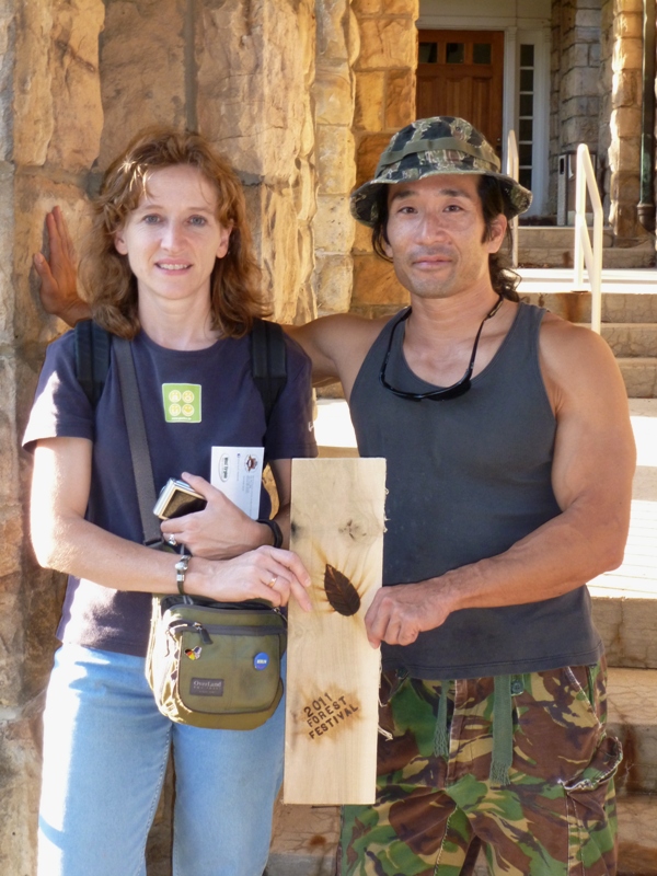 Norma and I holding piece of wood with event logo