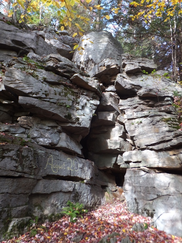 Steep rocks with graffiti that reads 'August 20'