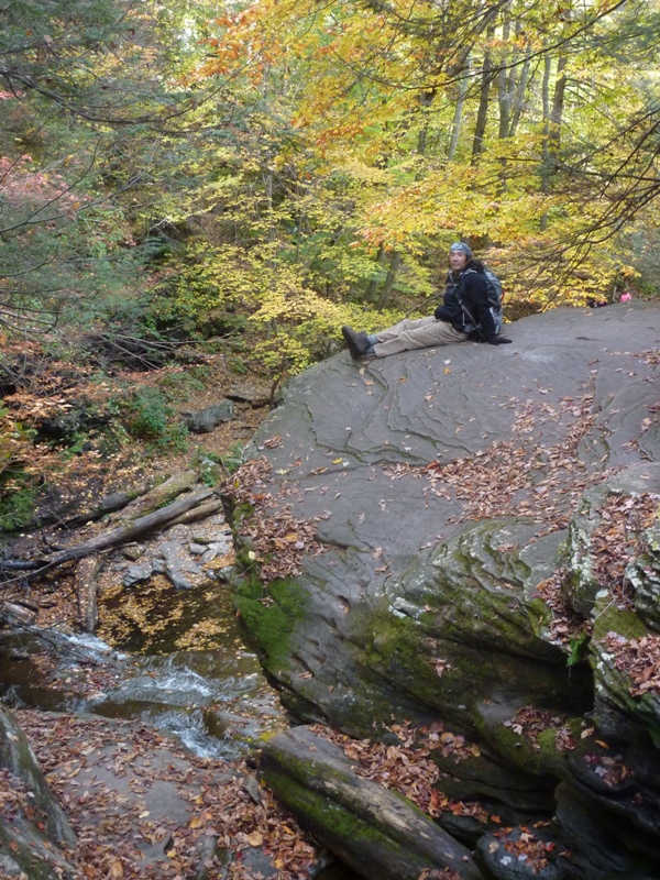 Me seated with legs outstretched on a big rock