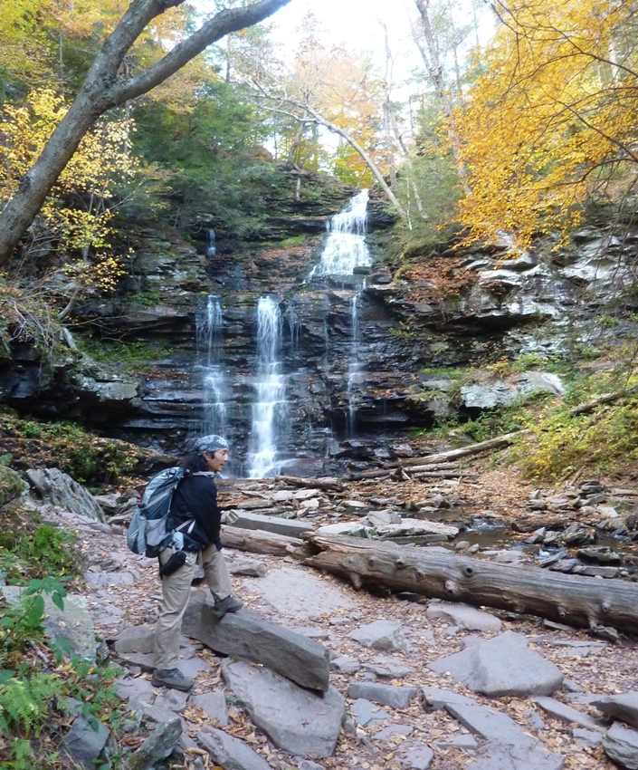 Me turned sideways as if I am thinking hard with the waterfall behind