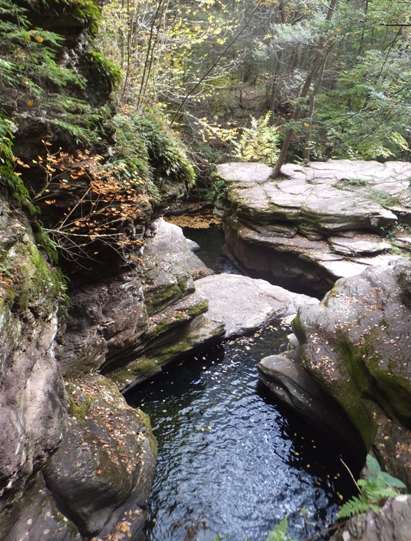 Steep, rocky drop into a pool of water