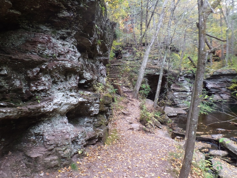 Trail with dramatic rocks bordering one side with water on the other