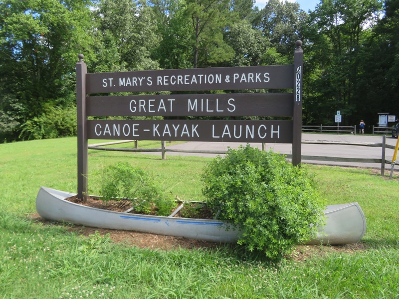 Sign and canoe at parking lot entrance