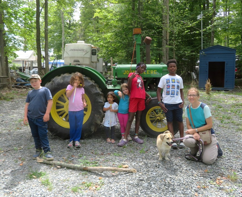 Norma, Daphne, and the kids in front of a John Deere tractor at the campground