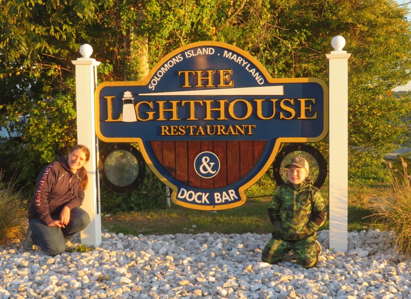 Laah and son in front of restaurant sign