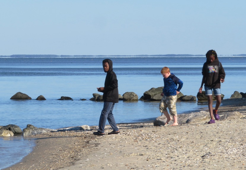 Kids on the beach with calm water of the Chesapeake Bay behind