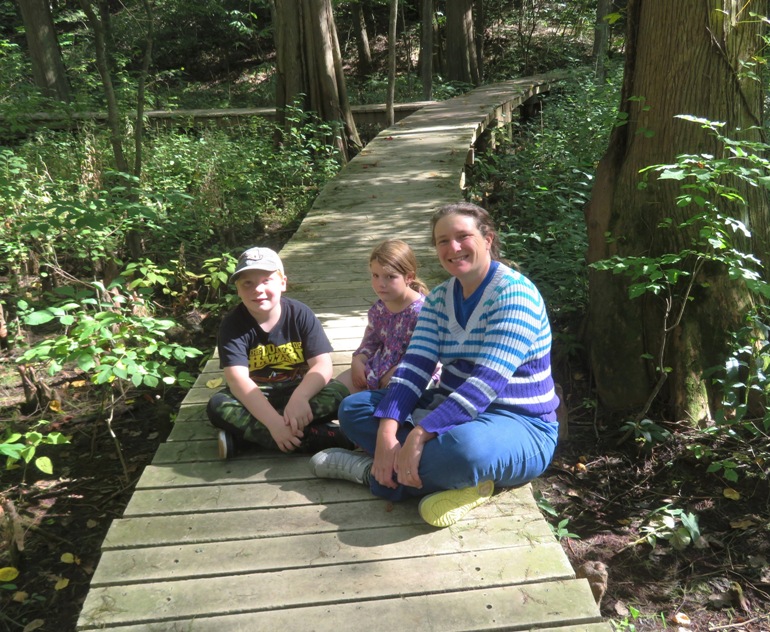 Laah and her two kids sitting on the boardwalk