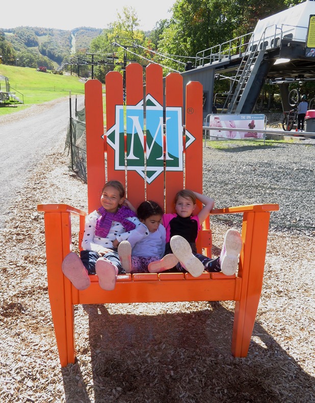 Three young girls on giant orange chair