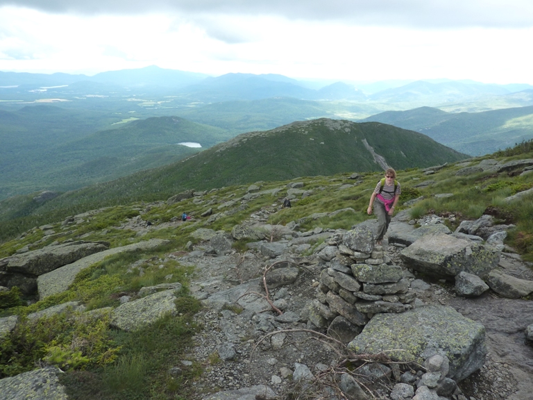 Norma hiking up a hill with mountains in the background