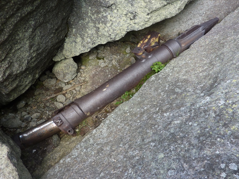 Big metal part from plane between rocks