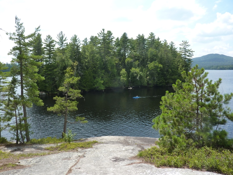 People kayaking in front of neighboring island