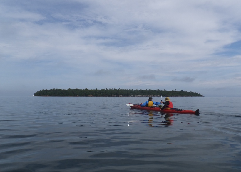 Steve and Carmen in their kayak with Devils Island in the distance