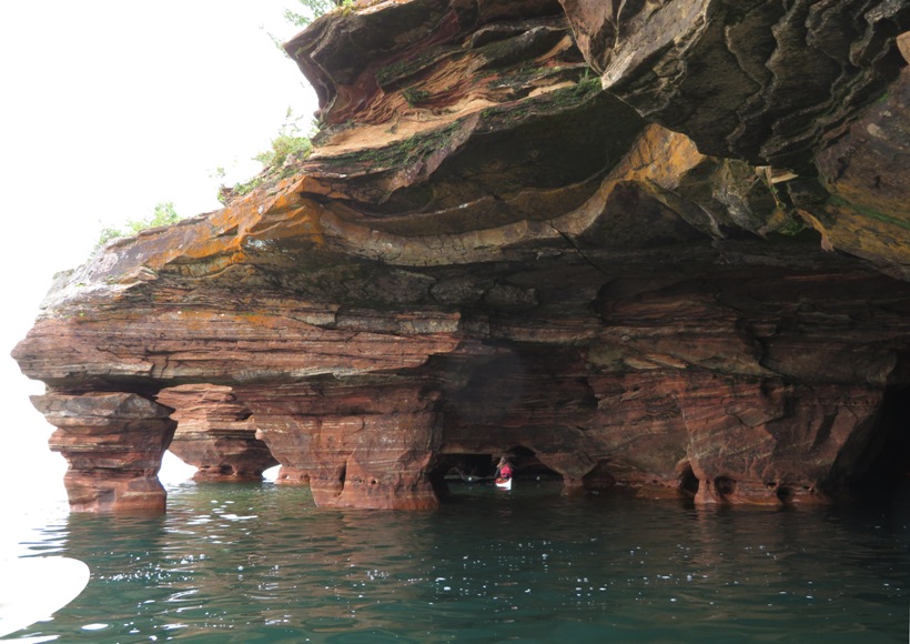 Britta in her kayak below a rock 