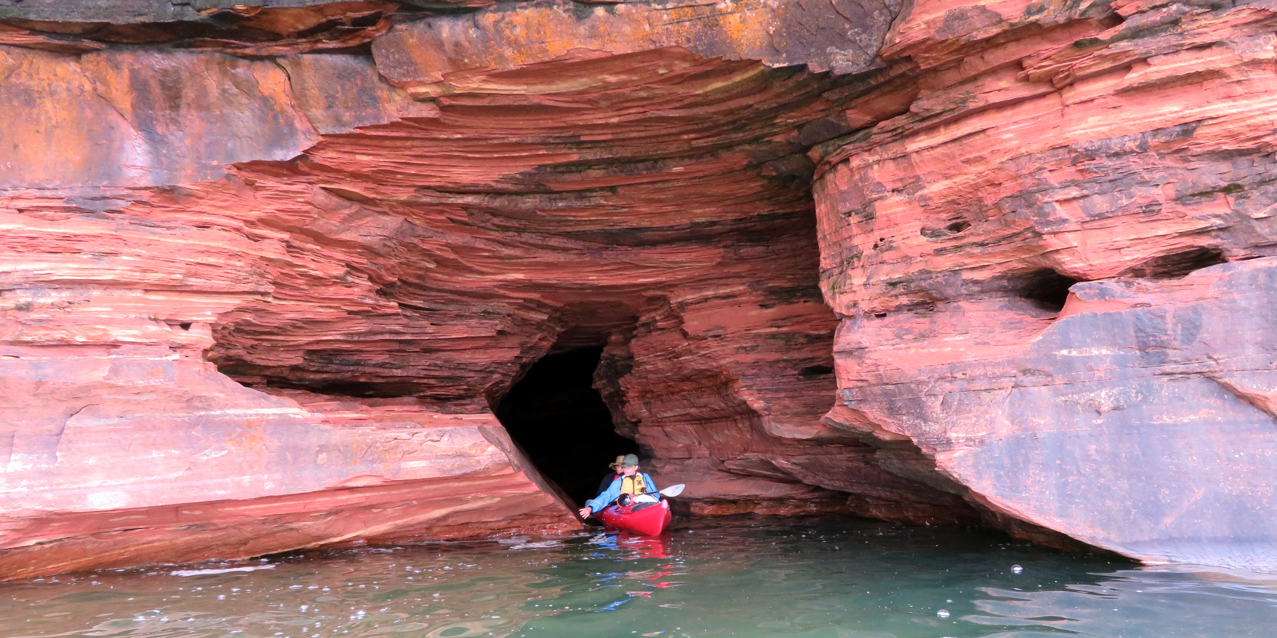 Steve and Carmen kayaking out of a red sea cave at Devils Island