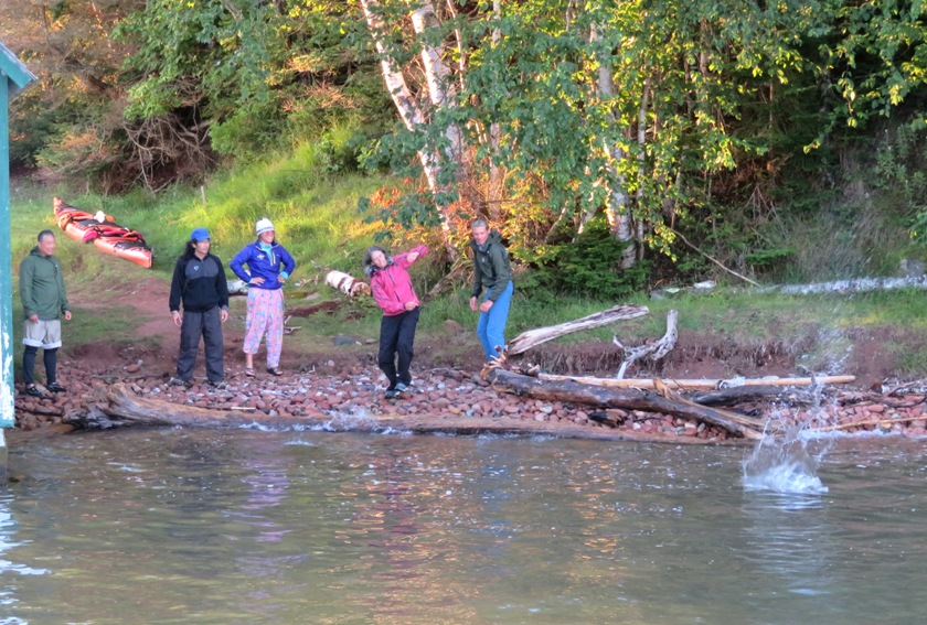 Carmen skipping a rock with others watching