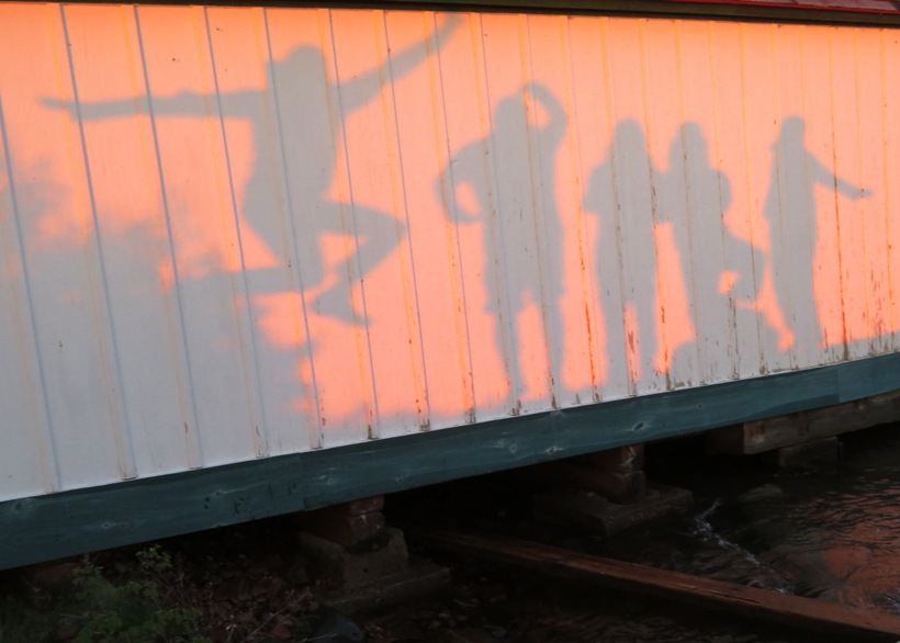 Shadows on the boat house of people making different shapes