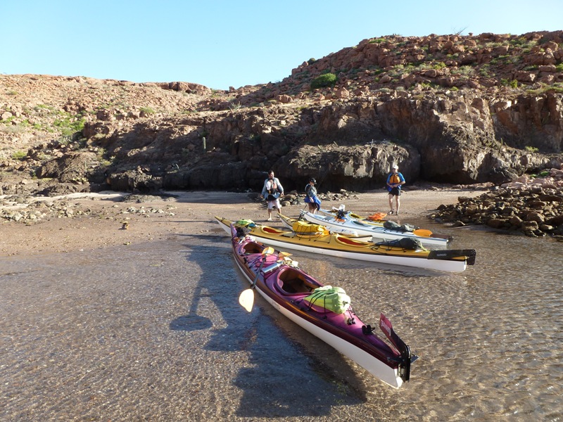 Kayaks in clear water by beach