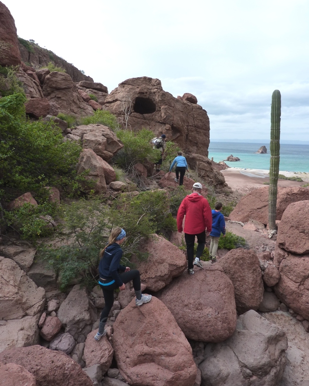 Group on hike with cave up high in the background