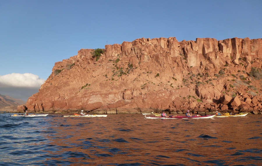 Starboard view of kayaks in front of red rocks