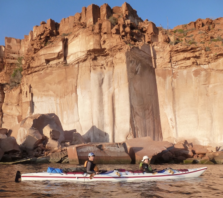 Norma and I in our 'Piloto' tandem kayak with big, rocky cliffs behind