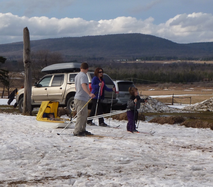 Family with little girl pulling ski cart