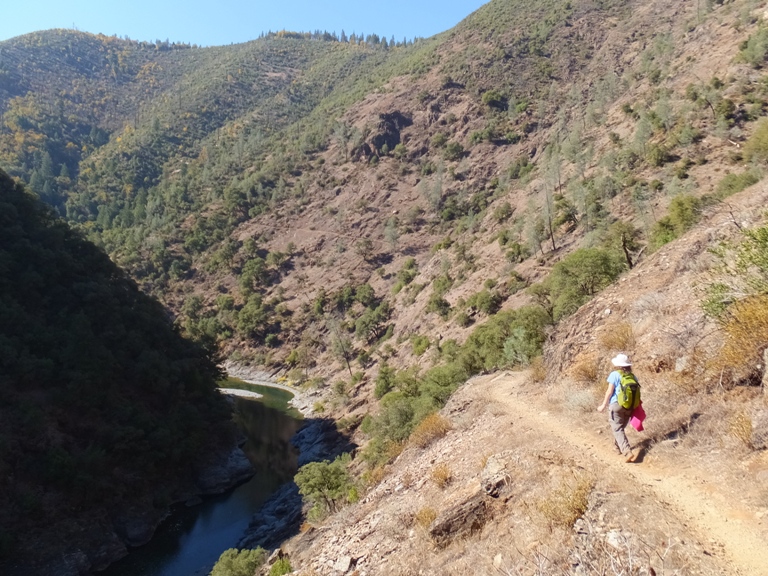 Norma on trail with bare hill next to her