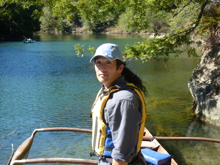 Me by the water with canoe in background