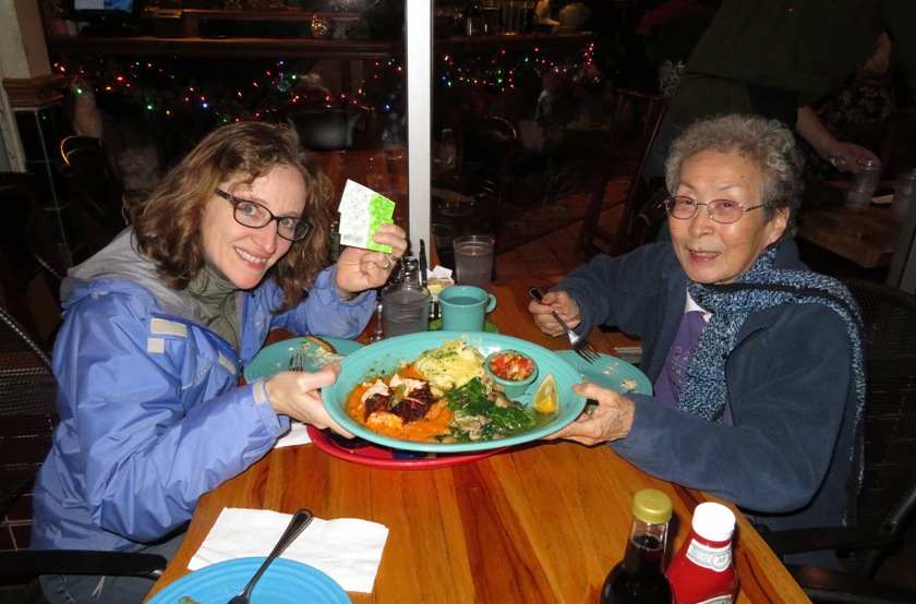 Norma and Mom holding a plate of food with Norma also holding tickets