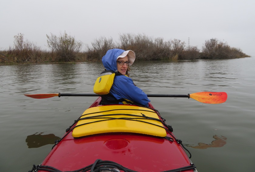 Norma wearing rain jacket, seated in kayak