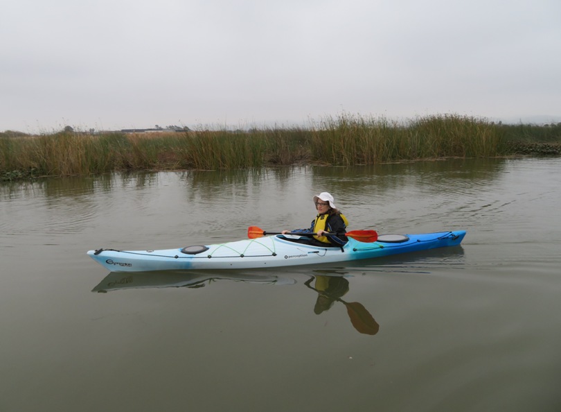 Norma on kayak surrounded by grasslands